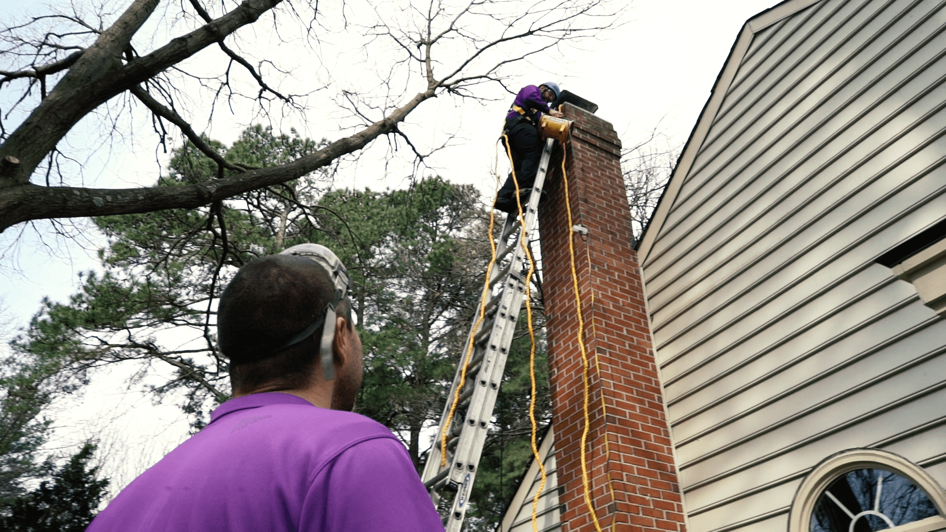 two technicians working on tall chimney