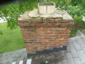 mason chimney with a chimney crown in need of repair