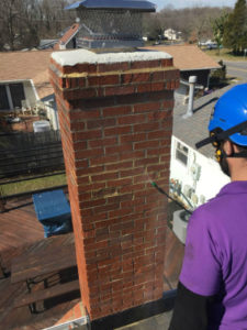 sweep on roof looking at chimney